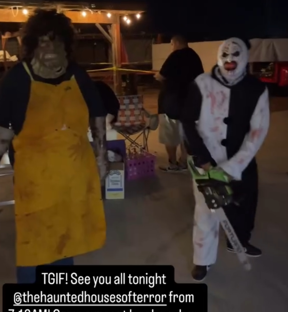 Two masked characters with a chainsaw waiting on the lot at night